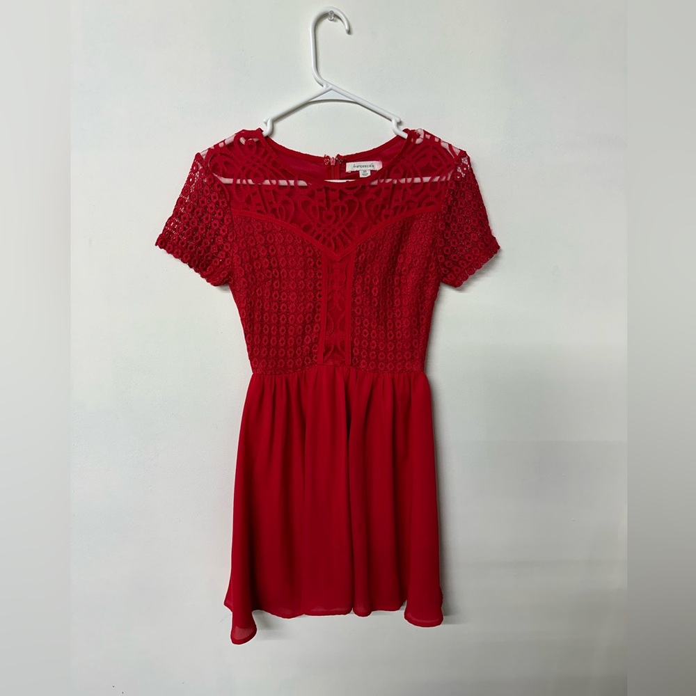 Short red dress with lace detail.